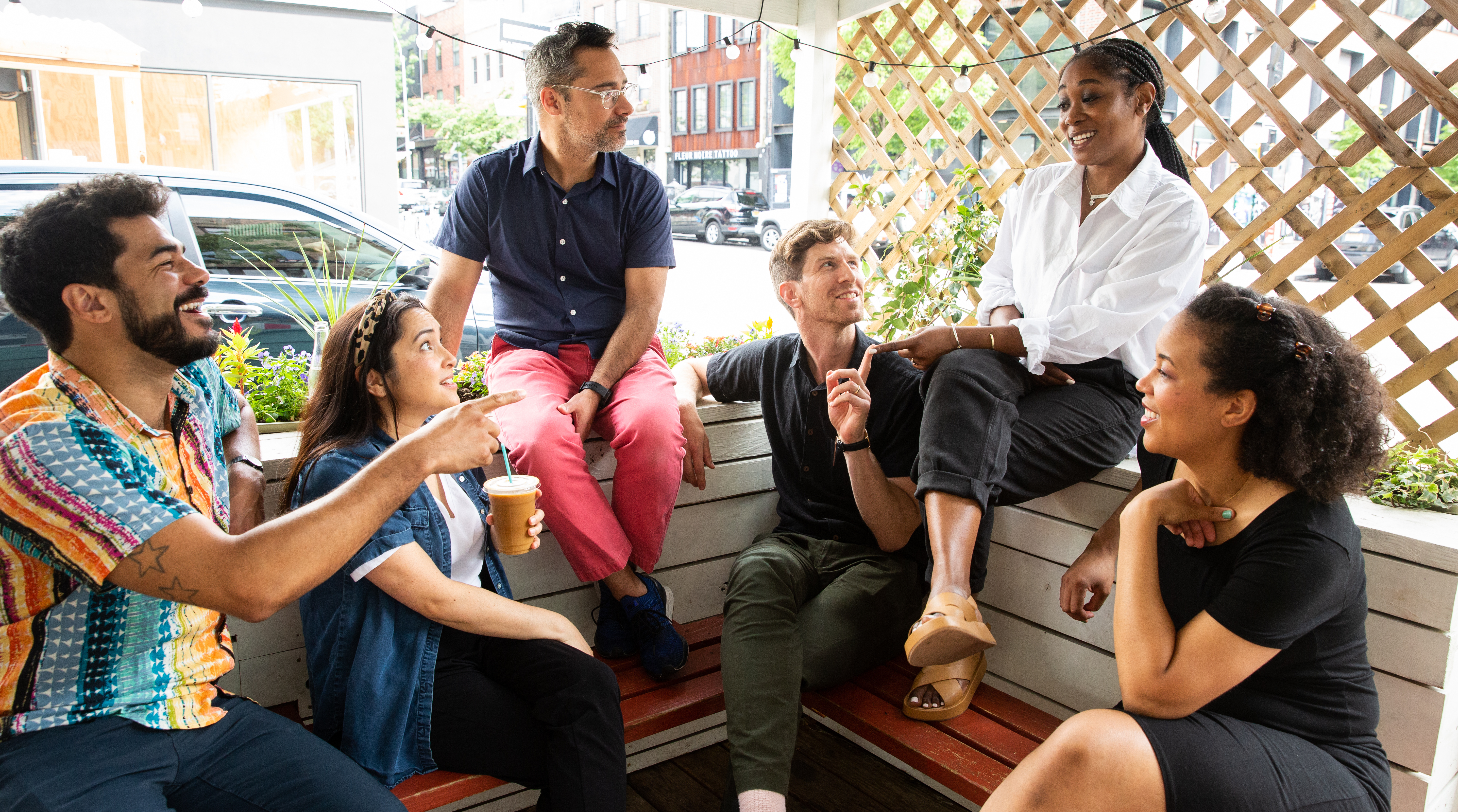 Six August pals brainstorm new ideas on a sidewalk porch in New York City.